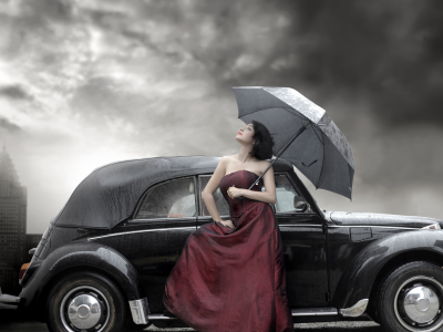 девушка модель, стоит у автомобиля с зонтиком