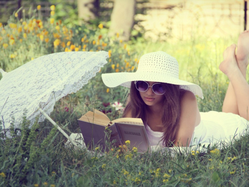 девушка, красивая, лежит на траве, читает книгу