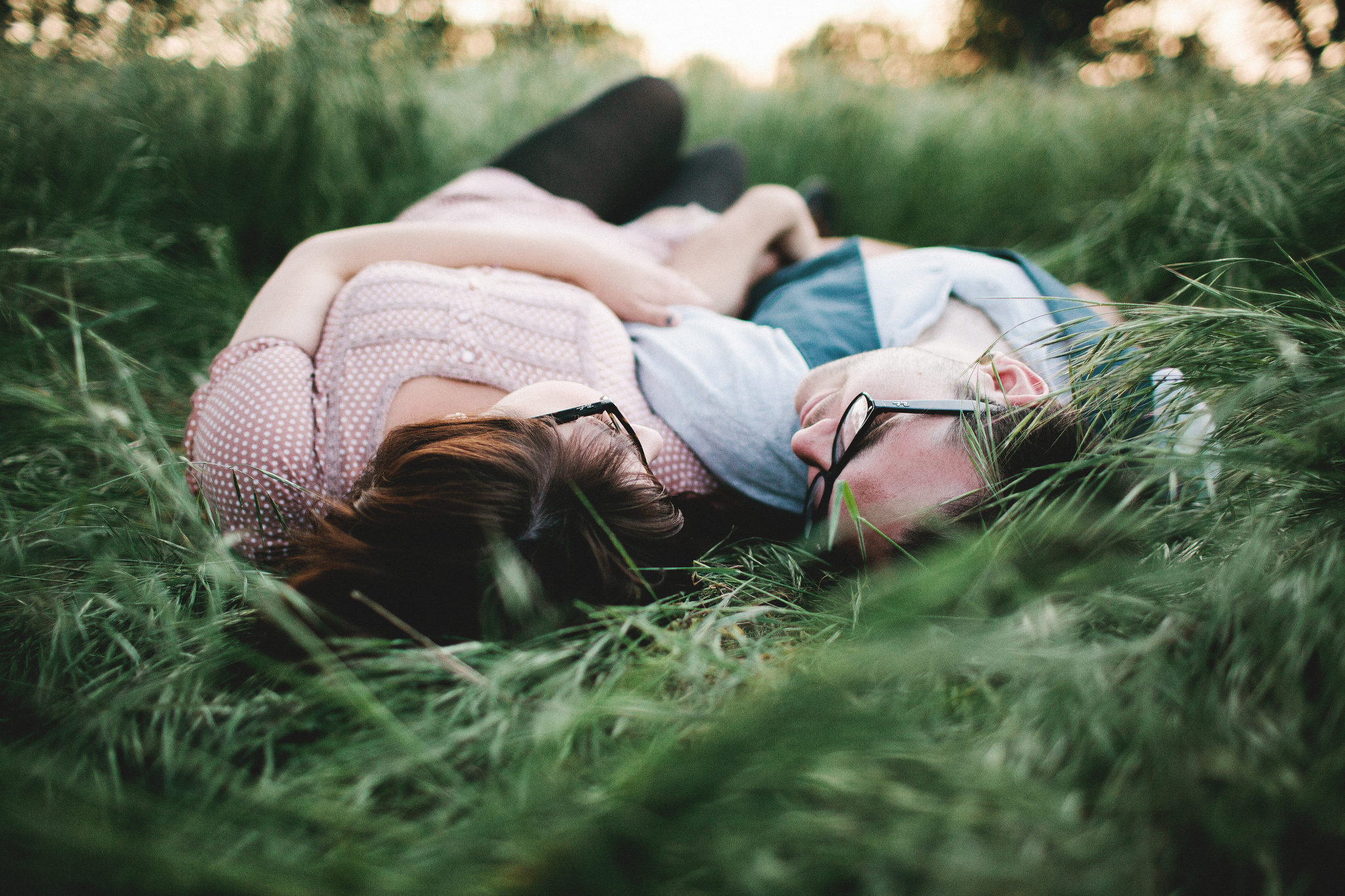 Однажды вечером в траве. Девушка лежит на траве. Пара валяется в траве. Двое лежат на траве. Влюбленные лежат на траве.