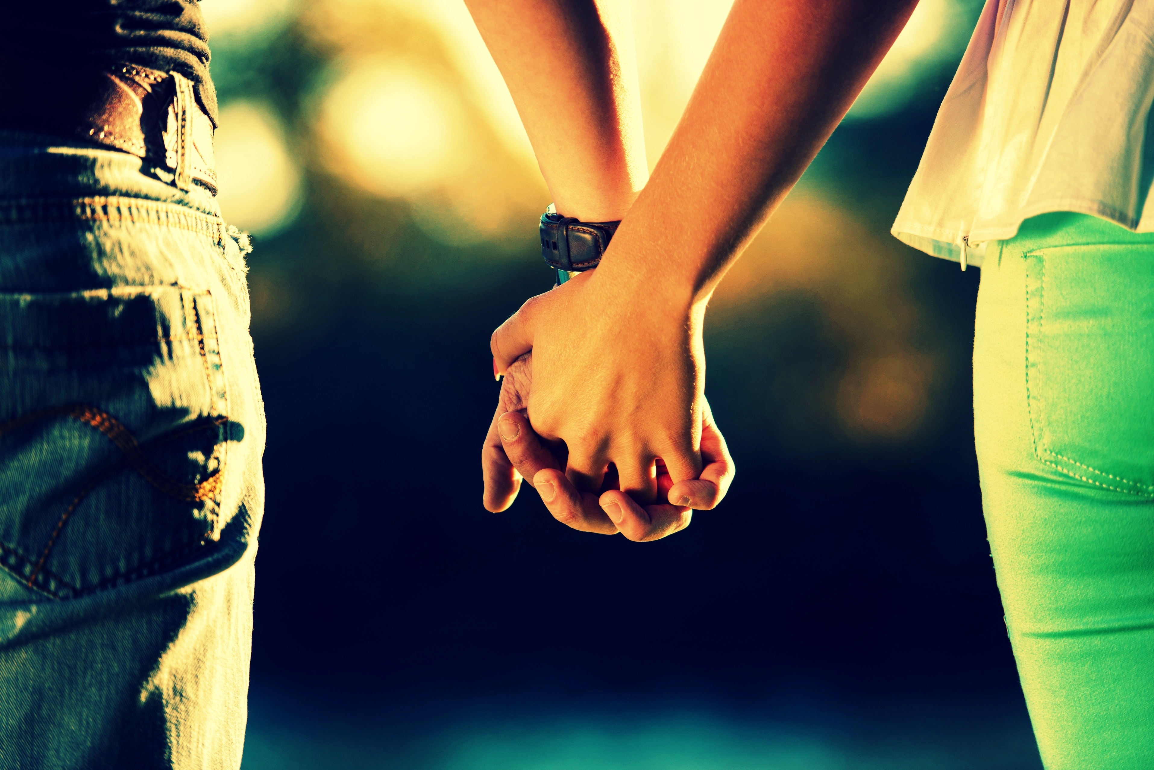 Пара в крокусе лежит за руки. Руки влюбленных. Держание за руки. Влюбленные за руки. Парень и девушка держатся за руки.