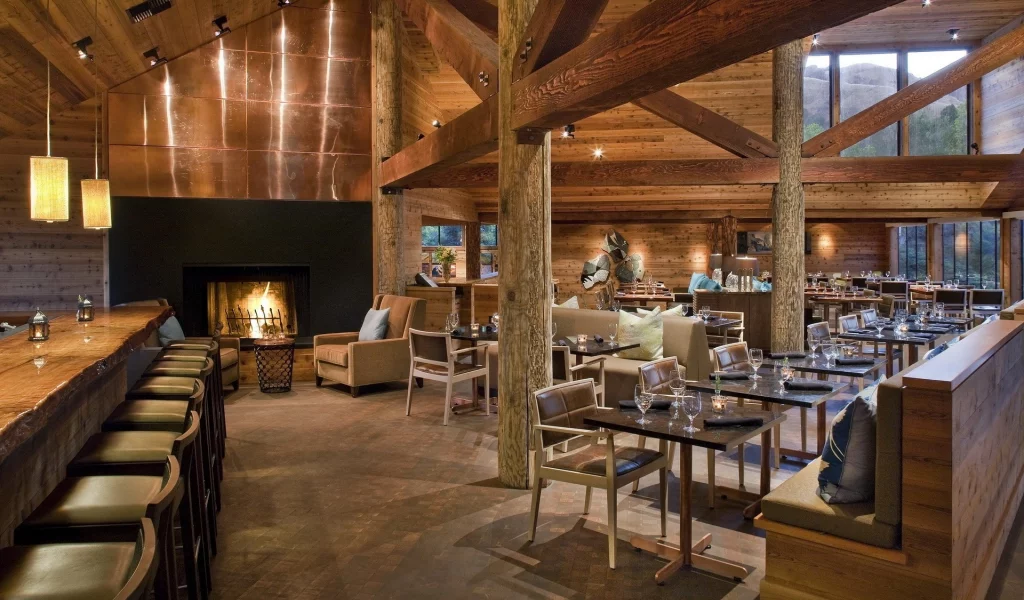 wine glasses, bar, wood, tables, fireplace, chairs, lights