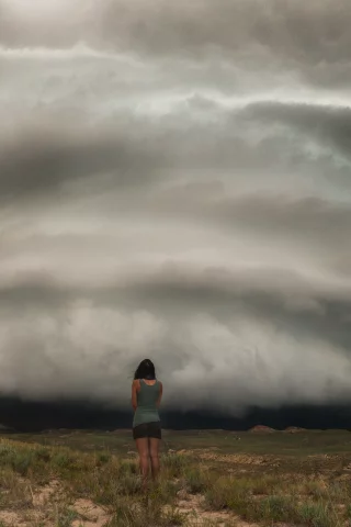 девушка, брюнетка, смотрит, ножки, шорты, майка, ураган, смерч, облака, тучи, поле, солнце, закат, рассвет, гроза, темнота, стихия, природа, трава, земля, небло
