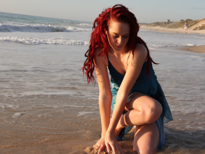 девушка, рыжая, позирует на берегу