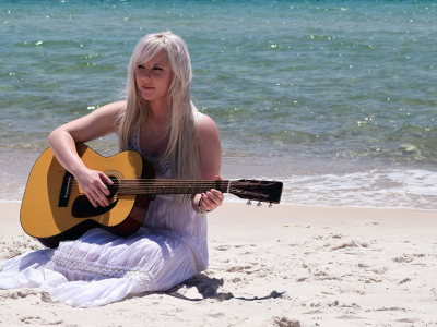 девушка, красивая с гитарой, на пляже